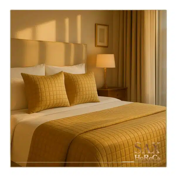 Dekorativni set u bež boji na krevetu u hotelskoj sobi